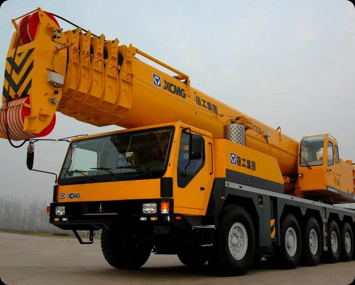 Крупный желтый кран XCMG XCA220, используемый для транспортировки грузов на строительной площадке