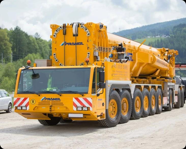 Мобильный кран жёлтого цвета Liebherr на площадке для тяжёлых грузоподъёмных работ