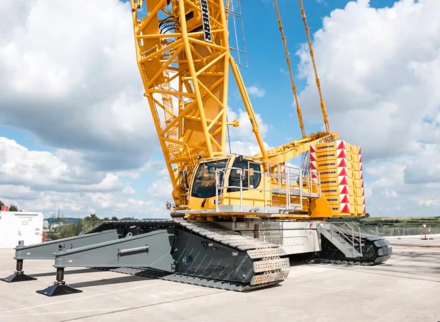 Крупный желтый кран Liebherr LR 1500, используемый для транспортировки грузов на строительной площадке